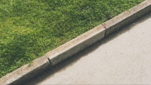 Concrete curbing vs landscape edging comparison showing two types of residential garden bed borders