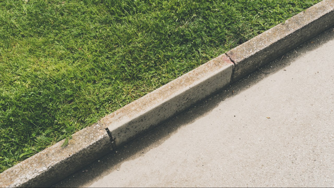 Concrete curbing vs landscape edging comparison showing two types of residential garden bed borders