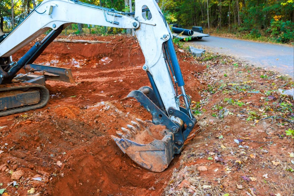 Residential building site with graded soil and surrounding land requiring drainage consideration