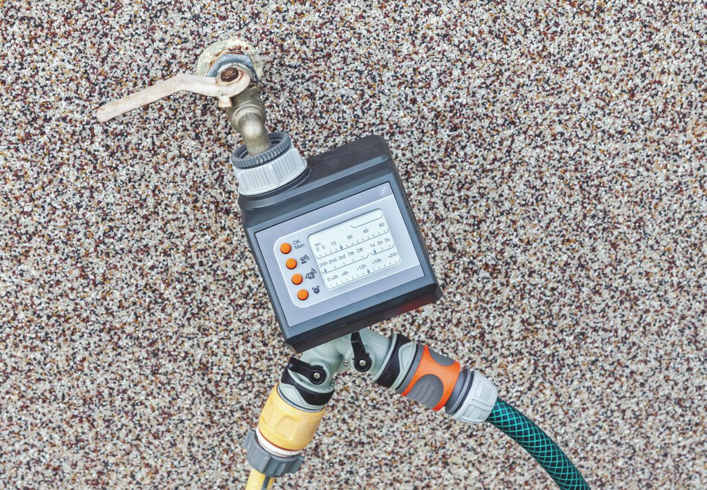 Irrigation dry spots North Port FL homeowner reviewing sprinkler controller settings